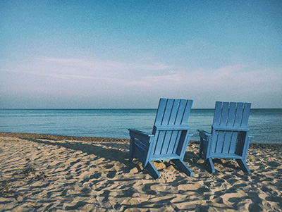 blue chairs on beach in the summer